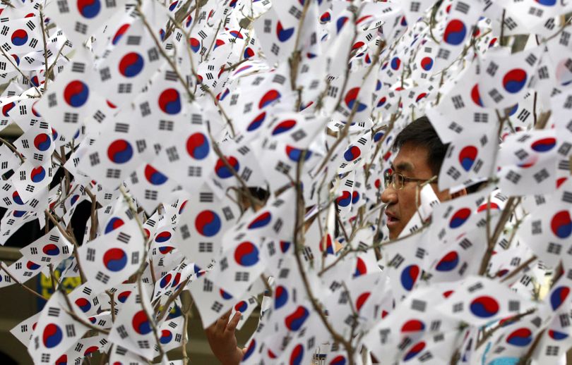 A man passes by South Korean national flags decorated on trees to celebrate the Aug. 15 Korean Liberation Day from Japanese colonial rule in 1945, in Seoul, South Korea, Monday, Aug. 15, 2011. (Lee Jin-man / Associated Press)