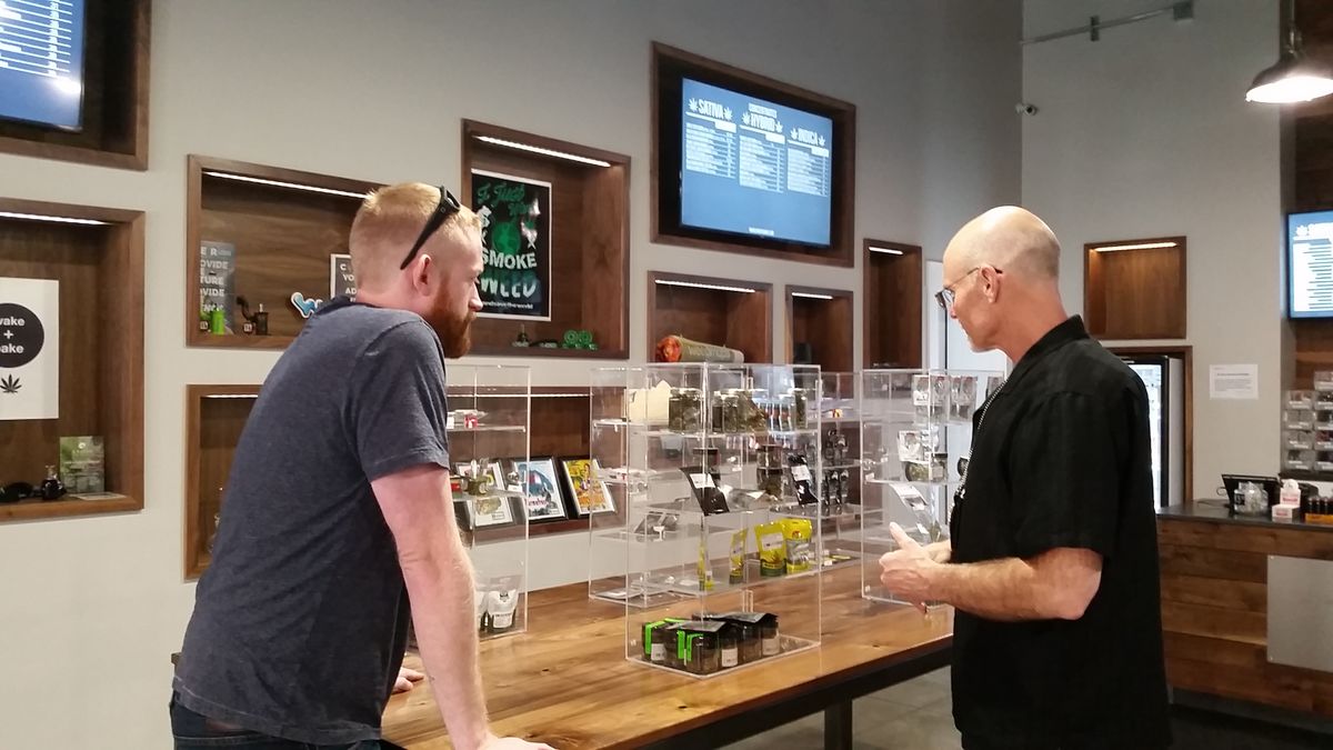 Lt. Rob Reynolds, right, from the Washington Liquor and Cannabis Board, talks with Justin Peterson, owner of Cinder.  (Joe Butler / EVERCANNABIS Writer)