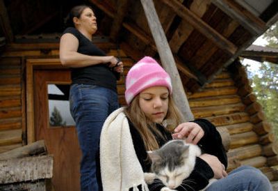 
Karry Opland, 11, of Clark Fork, holds her cat while her mother, Jennifer, talks about the flooded road leading to their house on Wednesday.  The family stayed with friends overnight until the road was repaired. 
 (Kathy Plonka / The Spokesman-Review)