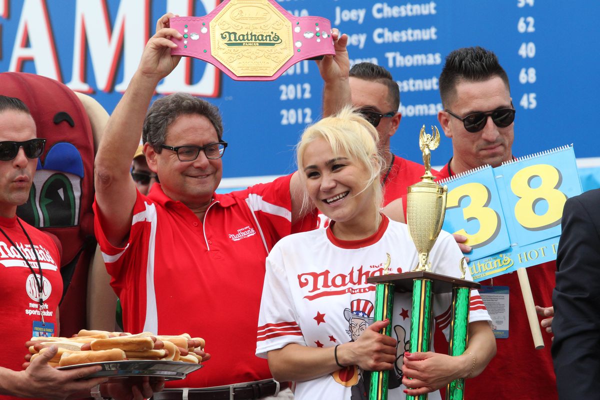 Miki Sudo holds her trophy after winning the hot dog eating contest women’s competition.
