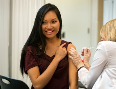 Hanh To, pharmacy student at WSU, prepares herself for a flu shot from second year pharmacy student MaryAnne Gellings in 2015 at the school’s south campus facility in Spokane.  (DAN PELLE)