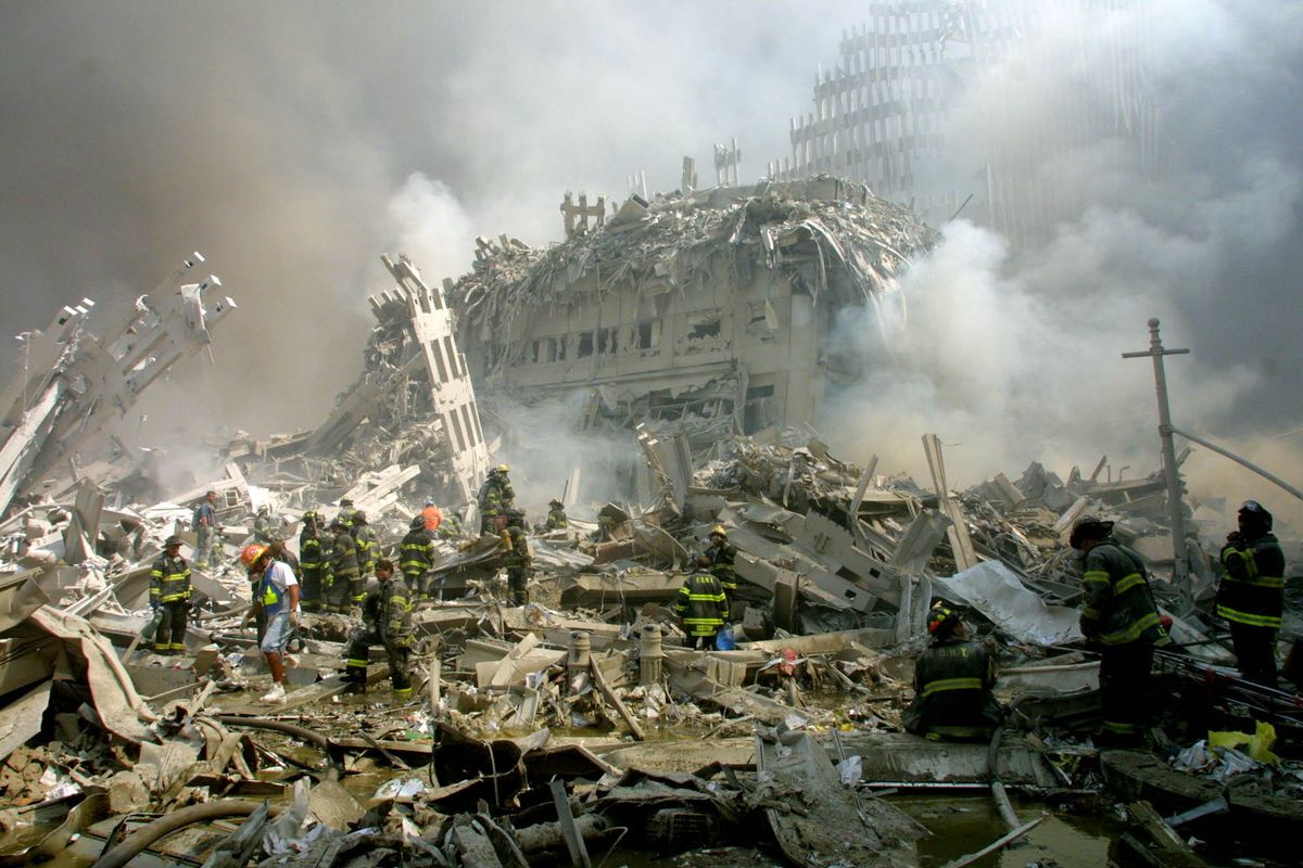 Firefighters walk through the rubble of the collapsed World Trade Center buildings on Sept. 11, 2001. (Associated Press)