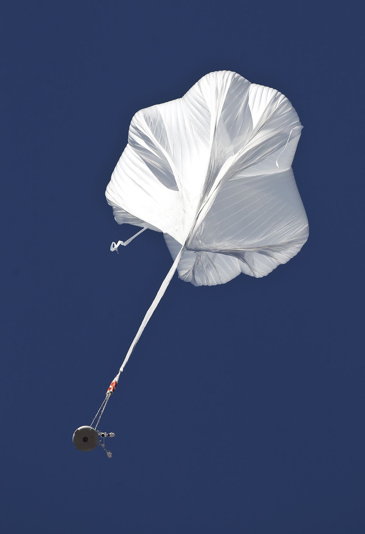 The capsule and attached helium balloon carrying Felix Baumgartner lifts off as he attempts to break the speed of sound with his own body by jumping from a space capsule lifted by a helium balloon, Sunday, Oct. 14, 2012, in Roswell, N.M.  Baumgartner plans to jump from an altitude of 120,000 feet, an altitude chosen to enable him to achieve Mach 1 in free fall, which would deliver scientific data to the aerospace community about human survival from high altitudes. (Ross Franklin / Associated Press)