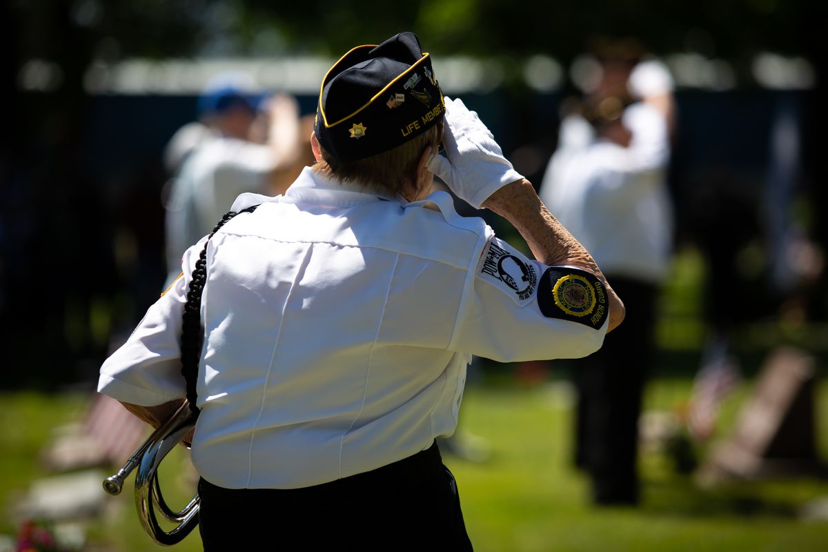 Color guard member Margaret Ogram salutes the flag during the national anthem while holding her bugle for the playing of TAPS during a rededication ceremony for St. Thomas Cemetery in Coeur d’Alene on Sunday. The well-attended pre-Memorial Day ceremony was presided over by Rev. John Mosier of St. Thomas and included prayers, a rifle salute from area VFW members who were present as the color guard, plus a patriotic sing-along.  (Libby Kamrowski/ THE SPOKESMAN-REVIEW)