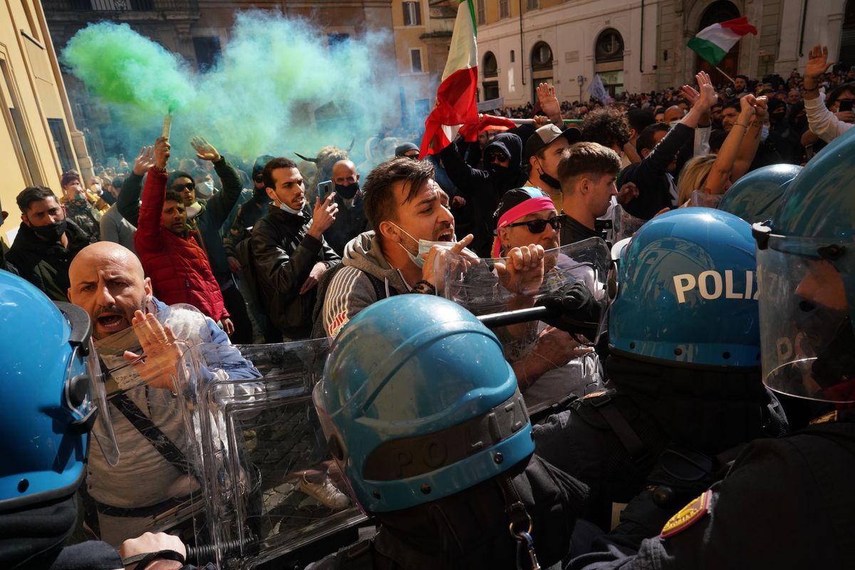 Demonstrators scuffle with Italian Policemen during a protest by Restaurant and shop owners outside the Lower Chamber in Rome, Tuesday, April 6, 2021. Demonstrators demanded to reopen their business and protested against restrictive measures of the Italian Government to cope with the surge of COVID-19 cases.  (Andrew Medichini)