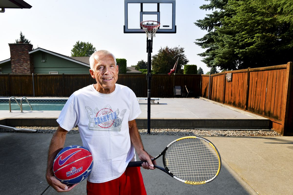 Longtime local sports organizer/enthusiast Jon Heimbigner displays two of his competitive passions on July 22 at his Spokane home. Heimbigner was instrumental in Hoopfest creating a senior division this year, with two brackets: one for 65-71 and another for over 71. Heimbigner almost wasn’t around to do it. Last November, several health ailments – the worst being bleeding in his brain – nearly killed him, but he’s back playing tennis and basketball.  (Tyler Tjomsland/The Spokesman-Review)