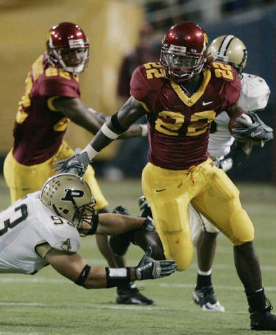 
Minnesota running back Laurence Maroney, right, evades a tackle by Purdue's Rob Ninkovich for an 8-yard gain in the first quarter. Maroney had a career-high 217 yards on 46 carries in the Gophers' double-overtime victory.
 (Associated Press / The Spokesman-Review)