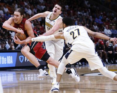 Miami Heat forward Kelly Olynyk drives to the basket against Denver Nuggets guard Jamal Murray (27) and center Nikola Jokic on Monday night in in Miami. Olynyk scored 30 points off the bench as the Heat defeated the Nuggets 149-141 in double overtime. (Wilfredo Lee / Associated Press)