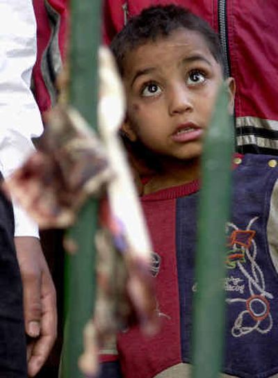 
An Egyptian boy looks at the scene as a blood-stained piece of a newspaper stuck to bars of a fence at the site of the explosion Saturday in downtown Cairo, Egypt.
 (Associated Press / The Spokesman-Review)