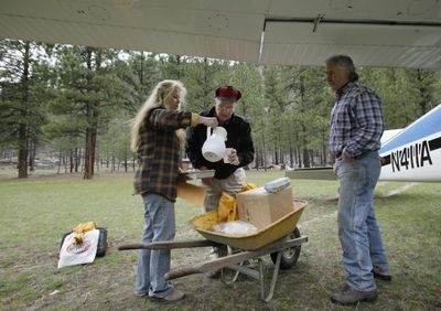 Greg Metz, right, caretaker of the Yellow Pine Bar property near the Salmon River in central Idaho’s Frank Church-River of No Return Wilderness, looks on as caretaker Sue Anderson pours a cup of coffee for pilot Ray Arnold in April after Arnold delivered their mail  in his airplane.  (Associated Press / The Spokesman-Review)