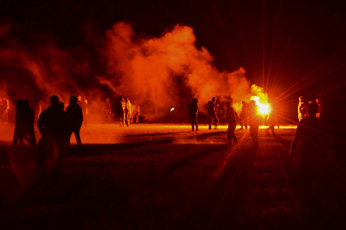 Youths stand in a field during clashes as police tried to break up an unauthorized rave party near Redon, Brittany, Friday June 18, 2021. Police repeatedly fired tear gas and charged clusters of violent partiers who hurled metal balls, gasoline bombs and other projectiles at security forces, according to images of the clashes shared online and the top government official in the region. Local authorities estimated about 1,500 people took part despite a local ordinance banning the event.  (STR)
