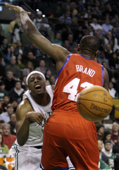 Celtics forward Paul Pierce, left, dumps the ball off as he passes behind the back of 76ers forward Elton Brand. (Associated Press)