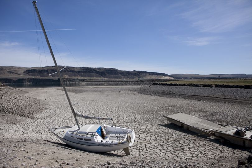 A sailboat sits on a dry riverbed in front of the Vantage Riverstone Resort on Thursday in Vantage, Wash. The river has been drawn down due to a crack in the Wanapum Dam. (Tyler Tjomsland)