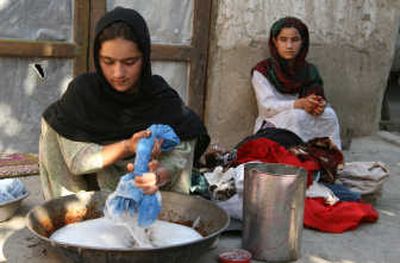 
Malia, 16, washes  clothes  next to her sister  in Jalalabad, Afghanistan. Unable to pay   for the sheep he bought,   their father was forced  to give up Malia,  now  engaged to the seller's  son. Associated Press
 (Associated Press / The Spokesman-Review)