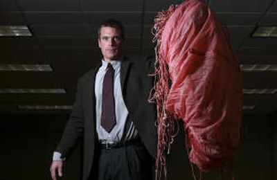 
At left, FBI agent Larry Carr displays a parachute, left behind by D.B. Cooper, at the FBI Seattle office Nov. 14. Below, a $20 plane ticket from Portland  to Reno, Nev., purchased by D.B. Cooper is part of the body of evidence gathered in the investigation of his hijacking. Seattle Post-Intelligencer
 (Photos by Andy Rogers Seattle Post-Intelligencer / The Spokesman-Review)