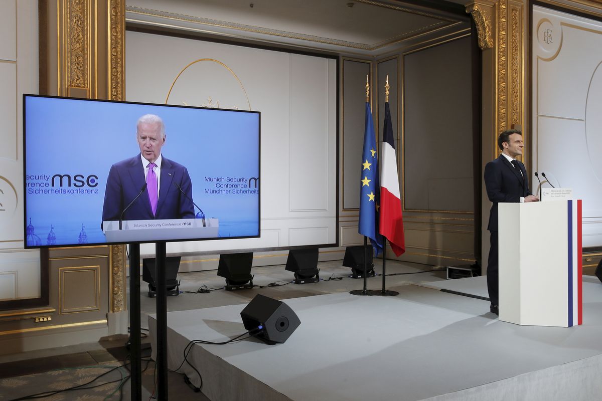 French President Emmanuel Macron, right, attends a video-conference meeting as U.S. President Joe Biden appear on a screen ahead of a 2021 Munich Security Conference at the Elysee palace in Paris, Friday Feb. 19, 2021.  (Benoit Tessier/Associated Press)