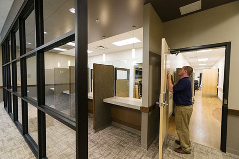 Josh McCoy, chief of environmental services for the U.S. Department of Veterans Affairs, adheres a sign to a door at Coeur d���Alene���s new VA clinic. (Shawn Gust/press)