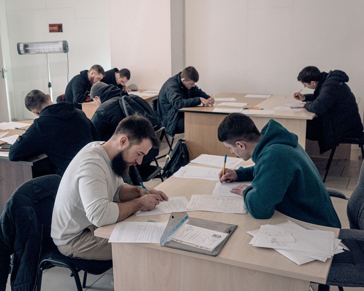 Volunteers fill out forms before being interviewed at an Azov Brigade recruitment center in Kyiv on March 21.   (Alice Martins/for The Washington Post)