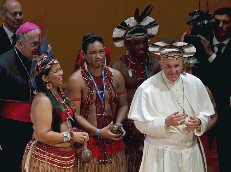 Pope Francis wears an indigenous headdress given to him by Ubirai Matos from the Pataxo tribe, fourth from left, after the pontiff spoke at Rio's Municipal Theater to an audience mostly made up of Brazil's political, business and cultural elite in Rio de Janeiro, Brazil, Saturday, July 27, 2013. Pope Francis is on the sixth day of his trip to Brazil where he will attend the 2013 World Youth Day in Rio. (Monica Imbuzeiro / Agencia O Globo)