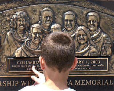 
Austin Fatlan, 10, of Morris, Ill., touches the commemorative wall sculpture honoring the Columbia crew at the Astronaut Memorial at the Kennedy Space Center visitor complex on Monday.
 (Knight Ridder / The Spokesman-Review)