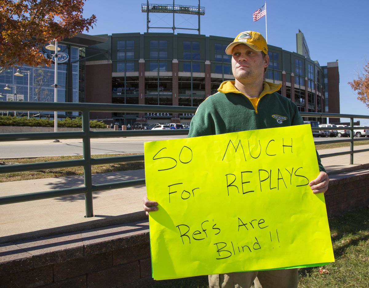 Green Bay Packers fan Mike LePak holds a sign in front of Lambeau Field on Lombardi Avenue, Tuesday, Sept. 25, 2012, in Green Bay, Wis., in protest of a controversial call in the Packers 14-12 loss to the Seattle Seahawks, Monday night in Seattle. Just when it seemed that NFL coaches, players and fans couldn