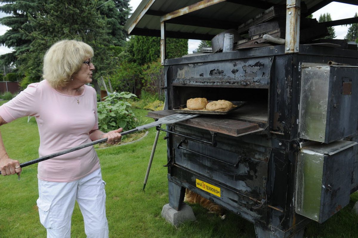 Mary Lee Abba-Gaston checks bread baking in her outdoor oven. Abba-Gaston has an electric brick oven in her backyard and offers baking lessons at her home. She bought the oven from Mount St. Michael’s kitchen. (Jesse Tinsley / The Spokesman-Review)