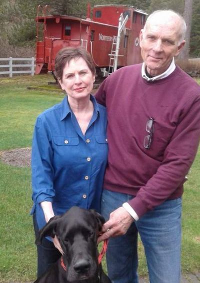 Courtesy photo Mary and Rocky Watson pose with Henry VIII in front of a caboose that serves as a guest house on their Rockford Bay property. (Coeur d'Alene Press photo)