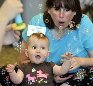 Taylor Pettit, 1 year old, and her mother Robin Pettit of Airway Heights, Wa., get an eyeful of bubbles as they participate in the Spokane County Moran Prairie Library Baby Lapsit program, June 4, 2009 in Spokane, Wa. Members of the class enjoyed stories, music and learning from Cindy Benson.  The program is Thursday's at 10:30 am through August 14.  DAN PELLE danp@spokesman.com (Dan Pelle / The Spokesman-Review)