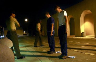 
Late-night arrivals:  Matt, left, and Robert Shipp  place their feet on yellow footprints at the Marine Corps Recruit Depot in San Diego. The Hauser Lake, Idaho, recruits were first off the bus at nearly midnight Monday for their processing into boot camp. 
 (Brian Plonka / The Spokesman-Review)