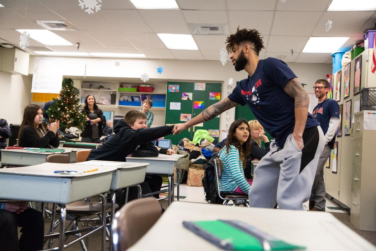 Gonzaga point guard Josh Perkins fist bumps a student in Mr. McIalwain