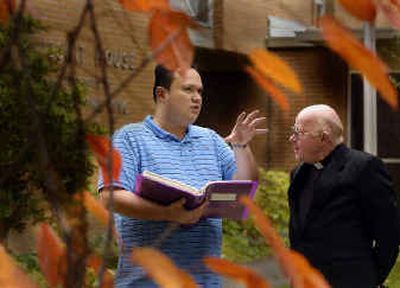 Richard Shaw and the Rev. Alfred Carroll look over a scrapbook of Amerasian children that Carroll has helped over the years. 
 (Christopher Anderson/ / The Spokesman-Review)