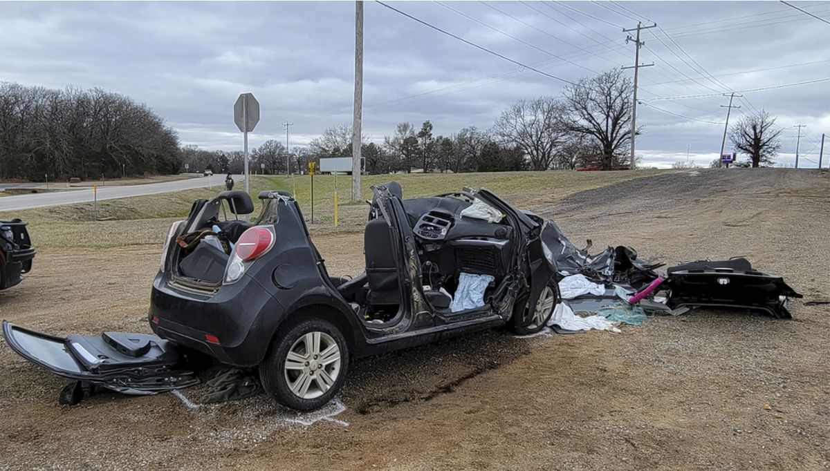 In this image provided by KFOR-TV, a heavily damaged vehicle is seen off a road in Tishomingo, Okla., following a two-vehicle collision in which six teenage students were killed, Tuesday, March 22, 2022. (TEL)