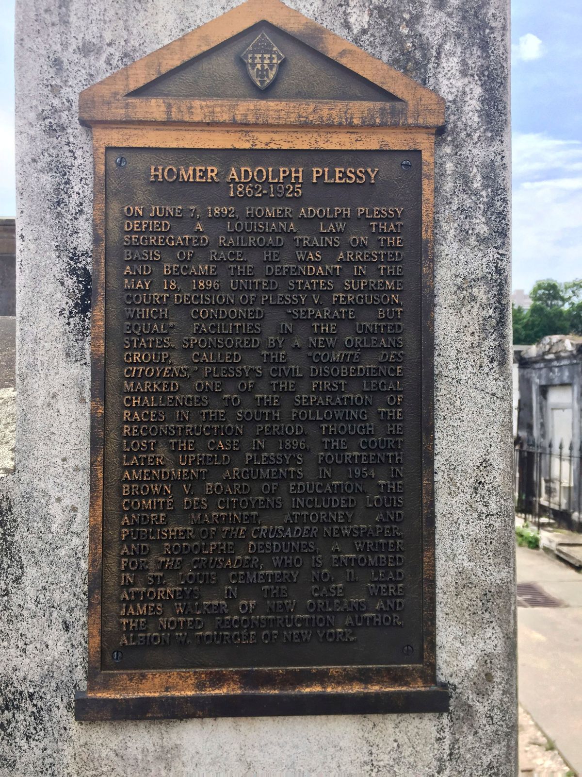 FILE - This June 3, 2018 photo shows a marker on the burial site for Homer Plessy at St. Louis No. 1 Cemetery in New Orleans. Homer Plessy, the namesake of the U.S. Supreme Court’s 1896 “separate but equal” ruling, is being considered for a posthumous pardon. The Creole man of color died with a conviction still on his record for refusing to leave a whites-only train car in New Orleans in 1892.  (Beth J. Harpaz)