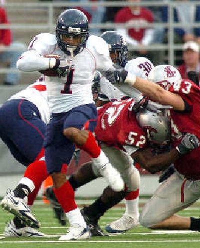 
Arizona's Syndric Steptoe (7) rips past Washington State's Greg Trent (52) and Brian Hall during a first-quarter kickoff return at Martin Stadium on Saturday. 
 (Joe Barrentine Associated Press / The Spokesman-Review)