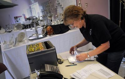 Marlene Connors, of A to Z Rental on East Francis Avenue, works Thursday on orders from customers who had orders with T&R Party and Event Rentals, which was destroyed in a fire Wednesday. (CHRISTOPHER ANDERSON / The Spokesman-Review)
