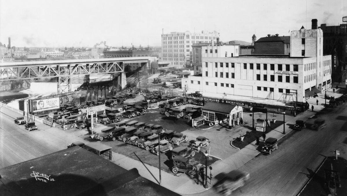 1930: The northeast corner of Monroe Street and Main Avenue was the site of a service station from the 1920s until the late 1960s, when Trent Avenue, now called Spokane Falls Boulevard, was extended from Lincoln to Monroe Street. The Sweeney Auto used car lot sat next to the gas station, run by Ernest Boberg and C.E. McLaughlin at that time. According to the newspaper classified ads in those days, most gas stations sold used autos. At right, the large white building is the Sears Roebuck store, built in 1930. When Trent Avenue was extended to Monroe Street in 1967, it claimed the parking lot behind the Sears store and the gas station property.  (Charles Libby photo/THE SPOKESMAN-REVIEW PHOTO ARCHIVE)