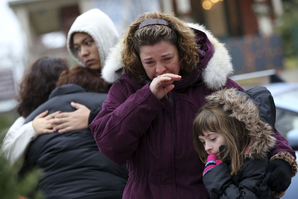 Mourners grieve at one of the makeshift memorials for victims of the Sandy Hook Elementary School shooting in Newtown, Conn. (Associated Press)