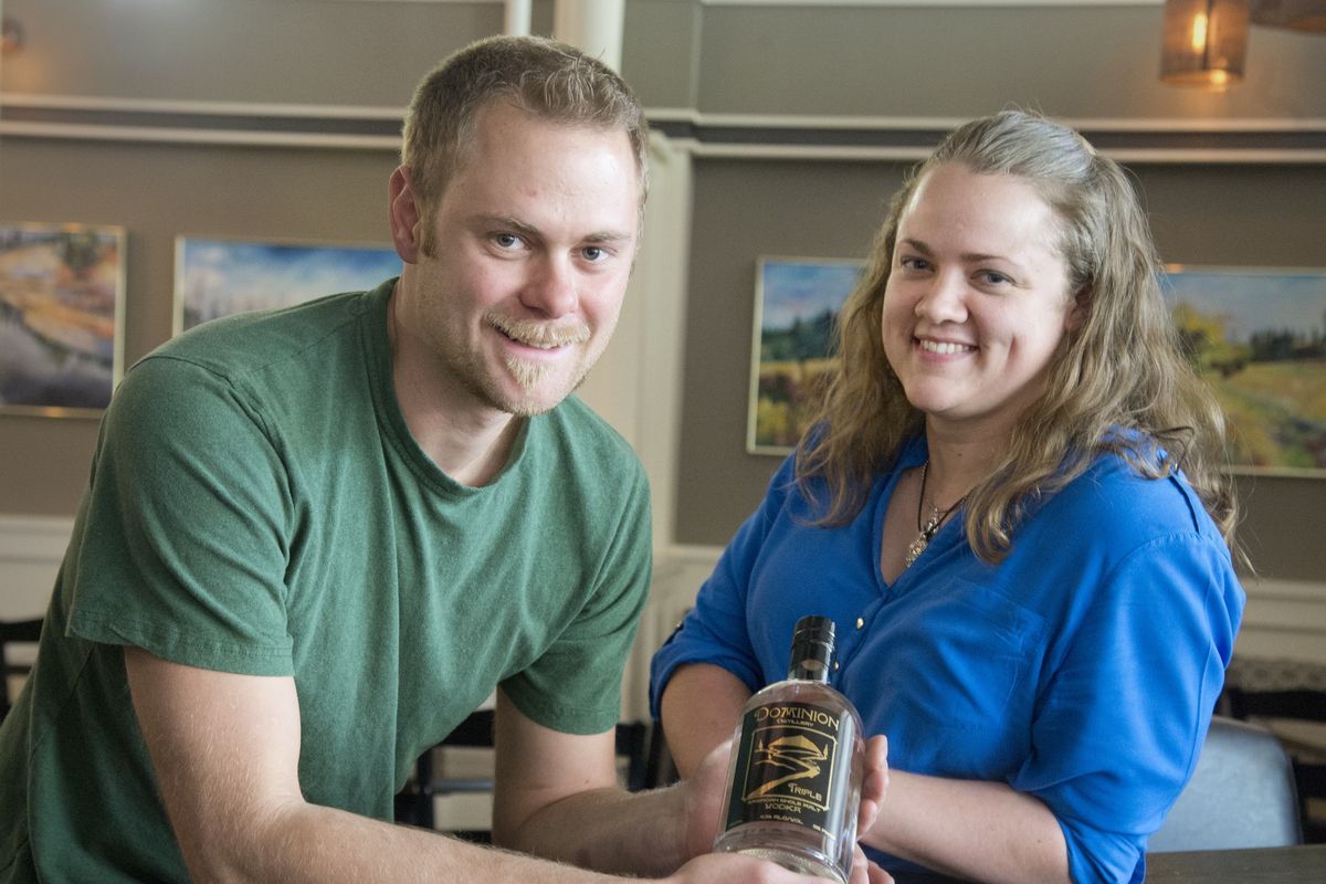 Henry Anderson and Saundra Richartz are two of the partners in Dominion Distillery in Colville. Anderson, who is the distiller, holds a bottle of the distillery’s single malt vodkas at Santé in Spokane. (Jesse Tinsley)