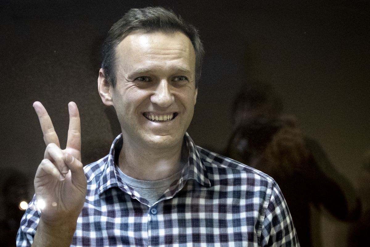 Russian opposition leader Alexei Navalny gestures as he stands behind a grass of the cage in the Babuskinsky District Court in Moscow, Russia, Saturday, Feb. 20, 2021. A Moscow court has rejected Russian opposition leader Alexei Navalny