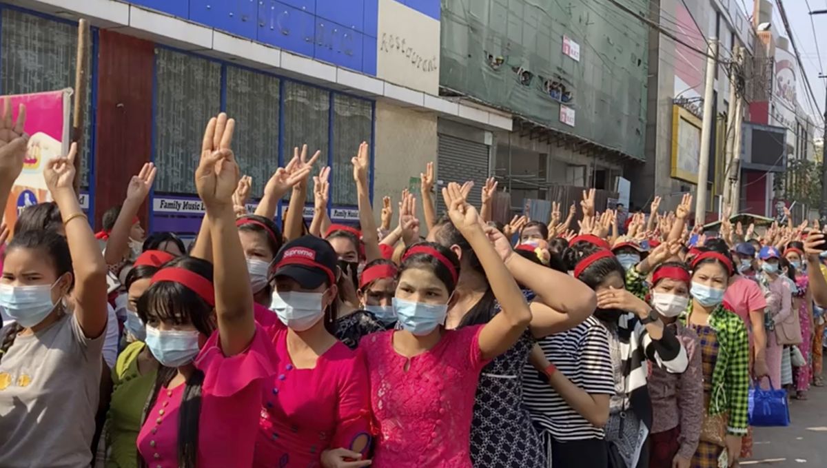 In this image made from video, protesters flash the three-fingered salute while they gather to march Saturday, Feb. 6, 2021, in Yangon, Myanmar. Myanmar’s new military authorities appeared to have cut most access to the Internet on Saturday as they faced a rising tide of protest over their coup that toppled Aung San Suu Kyi