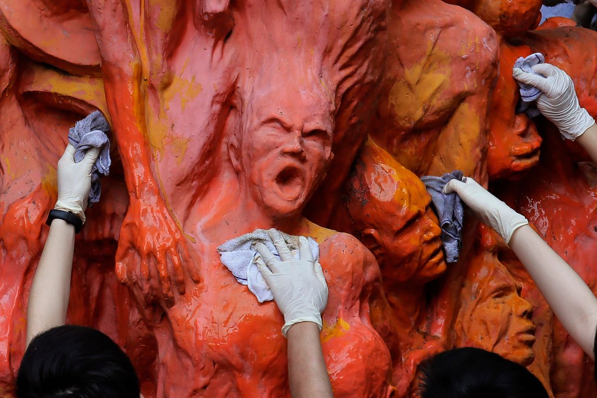 University students clean the "Pillar of Shame" statue, a memorial for those killed in the 1989 Tiananmen crackdown, at the University of Hong Kong Tuesday, June 4, 2019. A monument at a Hong Kong university that commemorated the 1989 Tiananmen massacre was boarded up by workers late Wednesday, Dec. 22, 2021, prompting fears over the future of the monument as the city