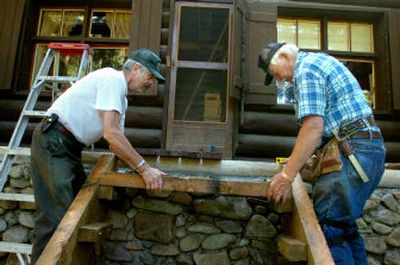 
Hank Jones, left, and Bob Sallee fit new stairs on an old cabin at Shoshone Park east of Mullan, Idaho, as part of a public service project by the National Smokejumpers Association. The group  replaced the front porch, steps and roof. The cabin will go into the pool of rental properties operated by the Forest Service. Below, Sallee uses a chisel and mallet to notch a log. They  are using traditional materials and many hand tools in the project. 
 (Photos by Jesse Tinsley / The Spokesman-Review)