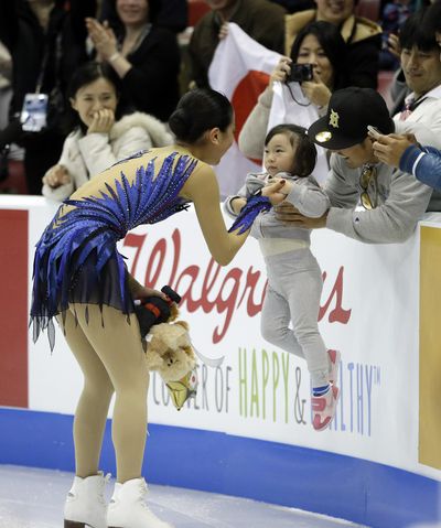 Mao Asada, of Japan, greets a fan after performing in the ladies free-skating routine at the Skate America in Detroit on Sunday. (Associated Press)