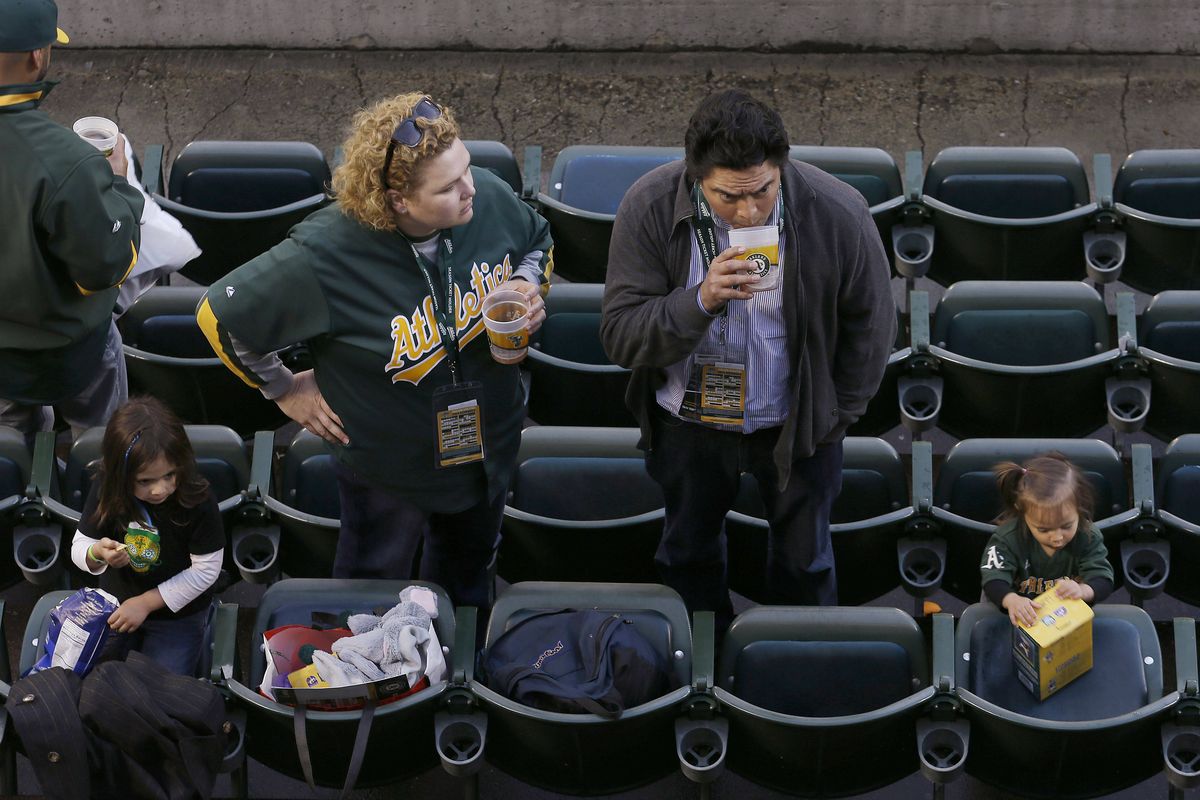 Fans stand at their seats after the game between Oakland and Seattle was postponed. (Associated Press)