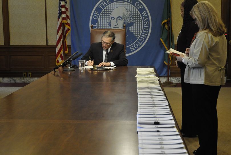 OLYMPIA -- Gov. Jay Inslee begins signing more than four dozen bills Thursday morning in his office conference room. (Jim Camden)