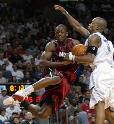 
Orlando's Steve Francis, right, fouls Miami's Dwyane Wade in the fourth quarter as the Heat pulled away for their eighth straight win.
 (Associated Press / The Spokesman-Review)