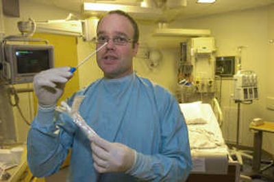 
Dave Olson, Sacred Heart Medical Center  registered nurse, will use a   swab to test for MRSA on new ICU patients. 
 (Dan Pelle / The Spokesman-Review)