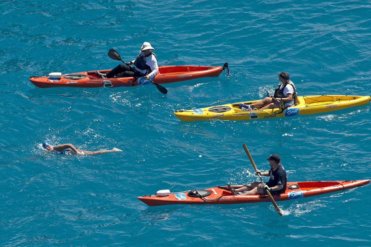 In this photo provided by the Florida Keys News Bureau, Diana Nyad, positioned about two miles off Key West, Fla., Monday, Sept. 2, 2013, is escorted by kayakers as she swims towards the completion of her approximately 110-mile trek from Cuba to the Florida Keys. Nyad, 64, is poised to be the first swimmer to cross the Florida Straits without the security of a shark cage. (Andy Newman / Florida Keys News Bureau)