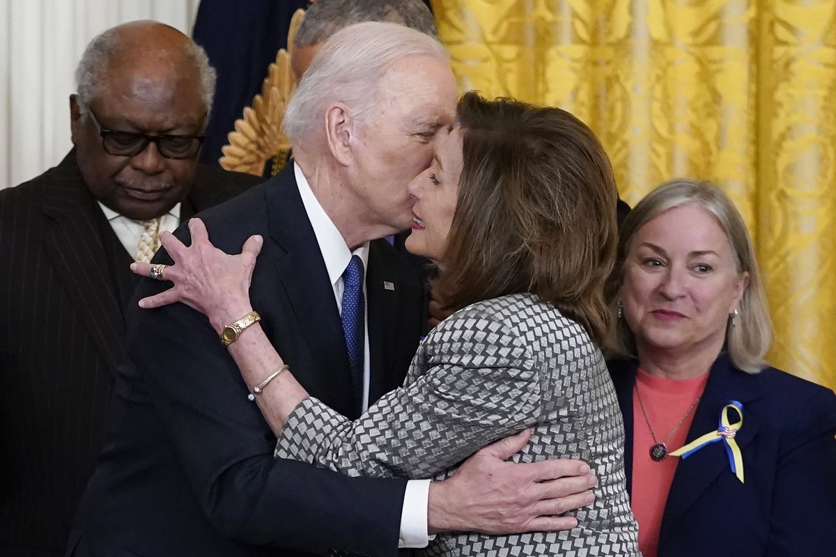 President Joe Biden kisses House Speaker Nancy Pelosi of Calif., during an Affordable Care Act event in the East Room of the White House in Washington, Tuesday, April 5, 2022. At left is House Majority Whip James Clyburn, D-S.C., and right is Rep. Susan Wild, D-Pa. Pelosi has tested positive for COVID-19 and is currently asymptomatic, her spokesman Drew Hammill said in a tweet Thursday, April 7.  (Carolyn Kaster)