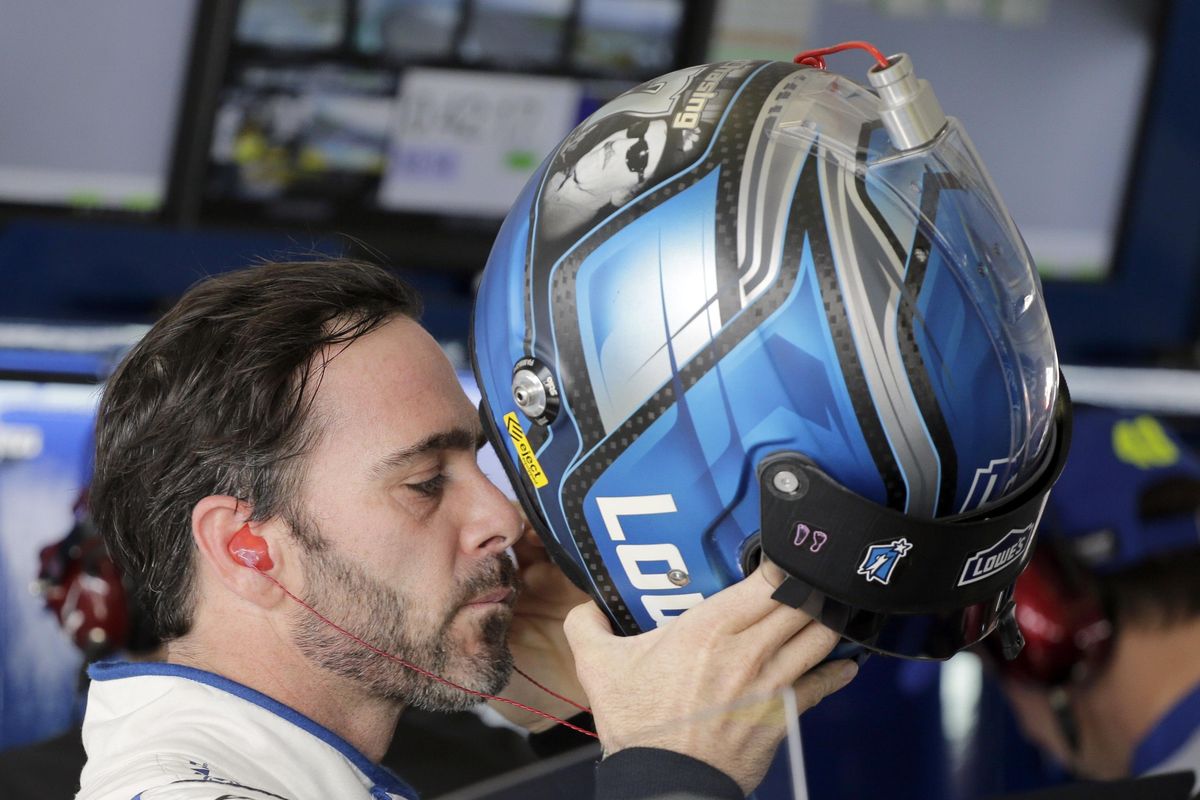 Jimmie Johnson puts on his helmet as he prepares for NASCAR Sprint Cup Series auto practice Saturday, Nov. 19, 2016, in Homestead, Fla. (Terry Renna / Associated Press)